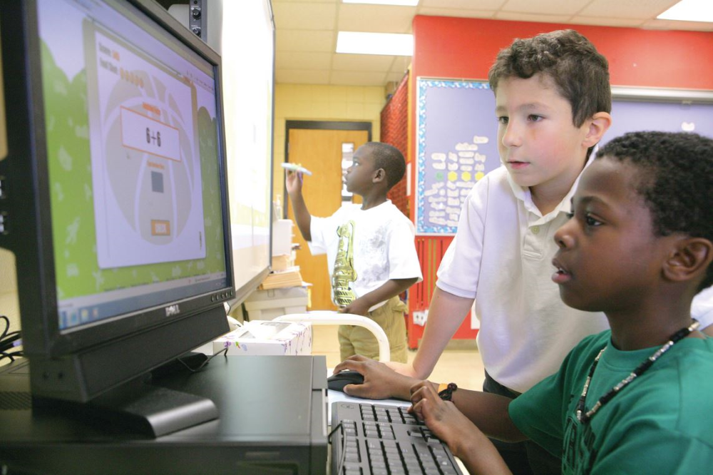 Enfants utilisant un ordinateur dans une classe d'immersion en français